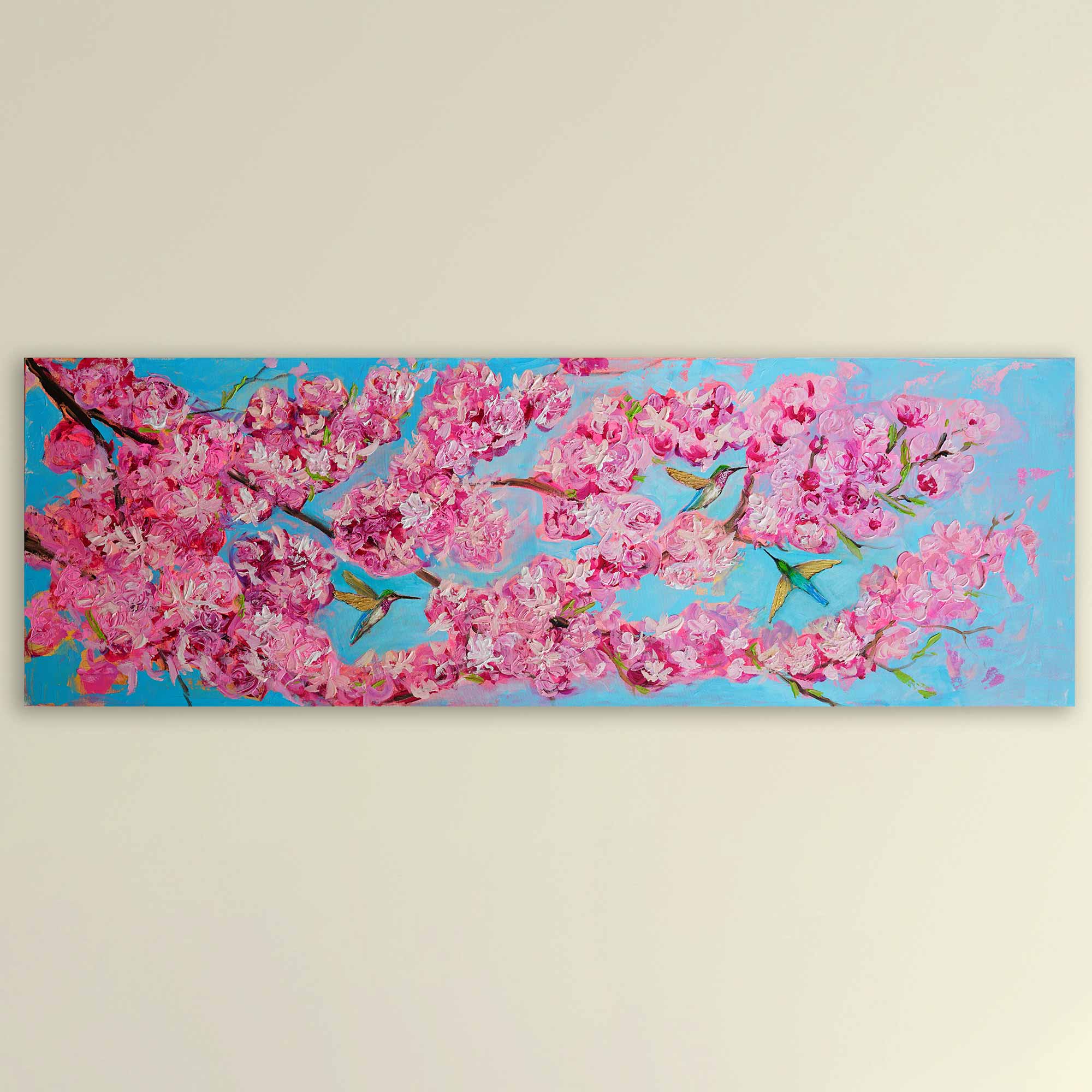 Painting of pink cherry blossoms with blue sky and birds on a beige wall.